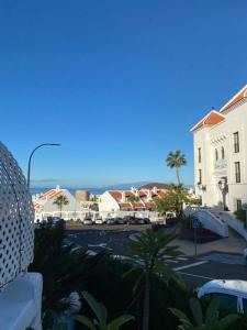 uma vista para uma rua com edifícios e palmeiras em Port Royal em Los Cristianos