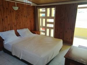 1 dormitorio con cama blanca y ventana en maison de ville, en Saint-Denis