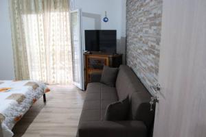 a living room with a couch and a brick wall at Corali luxury apartments in Malaki