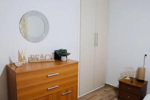 1 dormitorio con tocador de madera y espejo en Corali luxury apartments, en Malaki