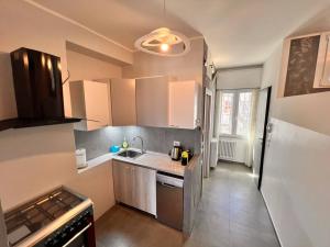 a kitchen with a sink and a refrigerator at Suite Riminese with Beach Service in Rimini