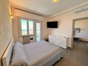 a bedroom with a large bed and a television at Suite Riminese with Beach Service in Rimini