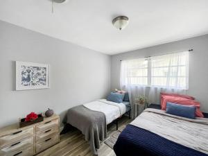 1 dormitorio con 2 camas y ventana en Miami Residential, en North Miami