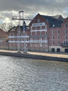 a large building next to a body of water at Luxury Riverside City Centre Apartment in York