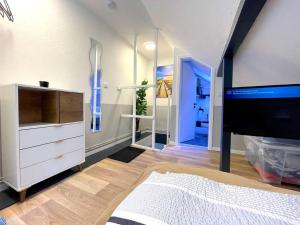 a bedroom with a dresser and a tv in a room at RobinsHomes-Industrial in Braunschweig