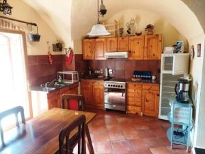 uma cozinha com armários de madeira e uma mesa e uma cozinha com um fogão em CASA MARIA Huge apartment in the heart of Bussana Vecchia em Sanremo