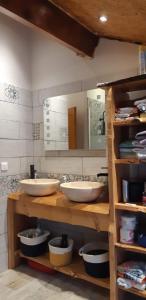 uma casa de banho com 2 lavatórios e um espelho em Maison proche de la nature em Quérigut