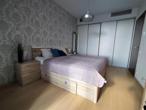 a bedroom with a large bed and a wooden floor at Cozy 2 rooms flat - Castle view in Bratislava