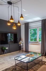 a living room with a glass table and a window at Apartman Pannonica Pin 0-24h in Slavonski Brod