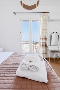 a bedroom with a bed with towels and a piano at Syros DouBleTS rooms in Ermoupoli