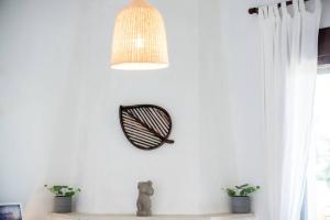 a clock on a white wall with two potted plants at Serenity Cove, The Fox s Lair Hospitality in Agia Paraskevi +23 photos