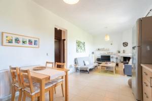 a kitchen and living room with a table and chairs at Serenity Cove, The Fox s Lair Hospitality in Agia Paraskevi