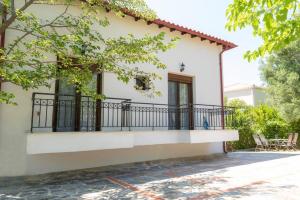 a white house with a balcony at Serenity Cove, The Fox s Lair Hospitality in Agia Paraskevi