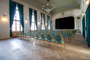 una habitación con una fila de sillas y un escenario en Hotel Prácheň, en Horažďovice