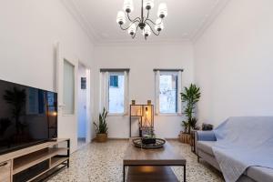 a living room with a couch and a tv at Syros DouBleTS Apartments in Ermoupoli