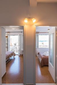 a room with two beds and a room with two windows at Syros DouBleTS rooms in Ermoupoli