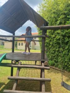 Una bambina in piedi su un tavolo da picnic in un parco giochi di Emufuleni river logde a Vanderbijlpark
