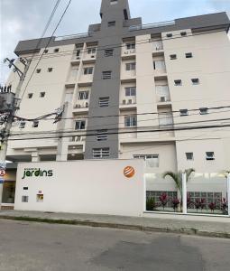 a large white building with a sign in front of it at Ap no centro piscina e churras in Ubatuba