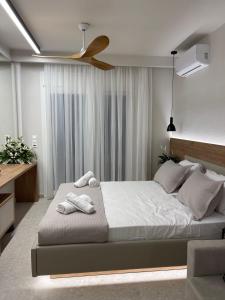 a bedroom with a large bed with a ceiling fan at Plagia Relax Hotel in Nea Plagia