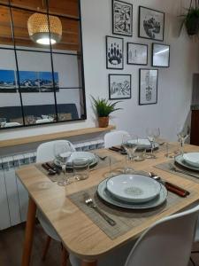 una mesa de madera con platos y copas de vino. en mcastet, casita aranesa en el valle de aran, en Bossòst