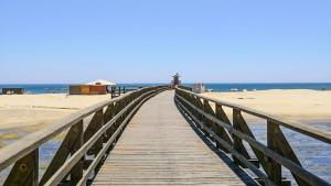 eine hölzerne Promenade, die zum Strand führt in der Unterkunft Vacaciones en España in Isla Cristina