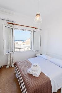 a bedroom with two beds and a large window at Syros DouBleTS rooms in Ermoupoli