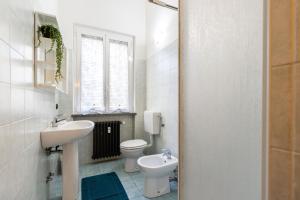 un bagno con lavandino, WC e finestra di [Sweet Arona] Beautiful Apartment, Netflix - Wi-Fi ad Arona Altre 25 foto