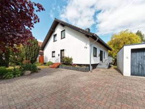 a white house with a brick driveway at Mein Strand Apartment in Scharbeutz