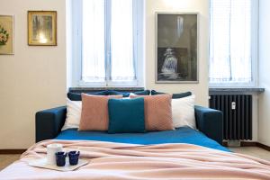 un letto blu con cuscini sopra di [Sweet Arona] Beautiful Apartment, Netflix - Wi-Fi ad Arona