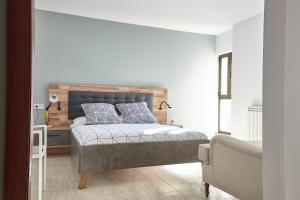 a bedroom with a bed with a wooden headboard at HOSTAL FONTAÑAN in La Pola de Gordón