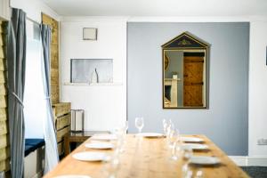 a long wooden table in a room with a mirror at The Farmhouse with two hot tubs in Siston