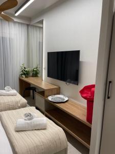 a hotel room with a television and two beds at Plagia Relax Hotel in Nea Plagia