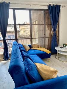a blue couch in a room with a large window at Rooftop Standing Place Carnot in Carcassonne