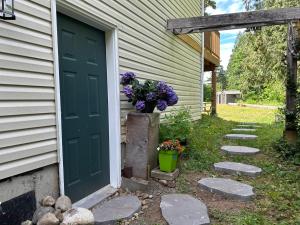 eine grüne Tür mit einem Blumentopf neben einem Haus in der Unterkunft Countryroad Cozy 2 Bedrooms basement suite1 in Nanaimo