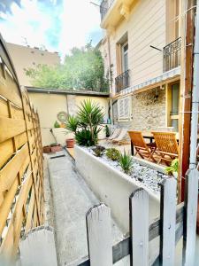 a courtyard with two chairs and a fence at Appartement 30m2 cosy avec terrasse in Menton
