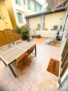 a patio with a wooden table and chairs at Appartement 30m2 cosy avec terrasse in Menton