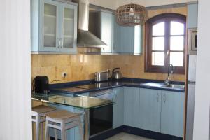 a kitchen with blue cabinets and a sink at Apartamento Frida Faro Park in Playa Blanca