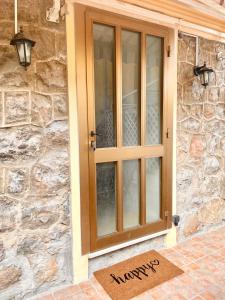 a wooden door on a stone house with a welcome mat at Appartement 30m2 cosy avec terrasse in Menton