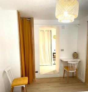 芒通的住宿－Appartement 30m2 cosy avec terrasse，一间设有镜子、一张桌子和椅子的客房