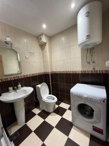 uma casa de banho com um WC, um lavatório e uma máquina de lavar roupa em b-612 em Petrovac na Moru