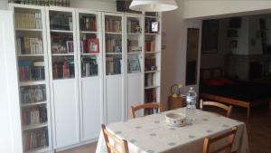 uma sala de jantar com uma mesa e prateleiras de livros com livros em Le Querce em Ancona