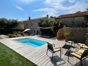 un patio trasero con piscina, sillas y una valla en mas provençale jardin piscine, en Saint-Cyr-sur-Mer