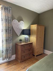 a bedroom with a heart on the wall and a dresser at Cosy 2 bed flat in Crickhowell in Crickhowell