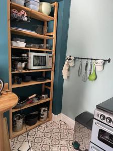una cocina con una estantería con microondas. en Cosy 2 bed flat in Crickhowell, en Crickhowell