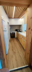 a kitchen with a white refrigerator and wooden cabinets at Santi e Benny Apartment in Ponta Delgada