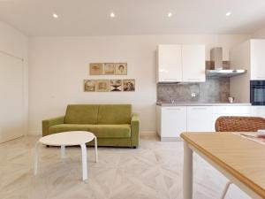 a living room with a green couch and a table at Colombo 477 Auditorium in Civitanova Marche