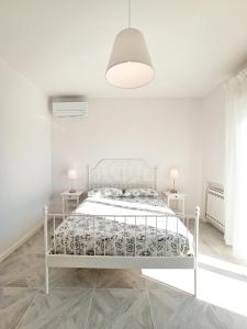 biała sypialnia z białym łóżkiem i dwoma stołami w obiekcie Colombo 477 Auditorium w mieście Civitanova Marche