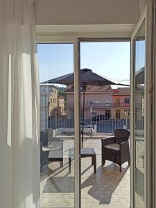 - un balcon avec une table, des chaises et un parasol dans l'établissement Colombo 477 Auditorium, à Civitanova Marche