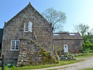 an old stone building with a window and stairs at Shire Cottage in Highpeak Junction