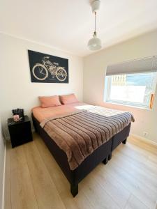 a bedroom with a bed and a picture of a bike on the wall at Ibsens in Bergen